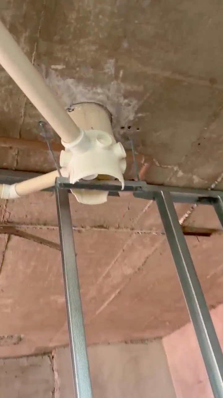 Conexão hidráulica em PVC fixada sob laje com suporte metálico